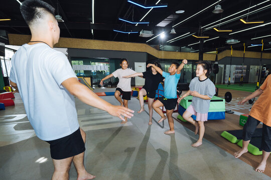 Asian coach instructing young kids
