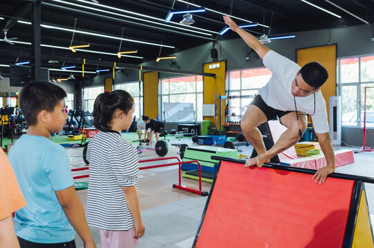 Asian coach instructing young kids