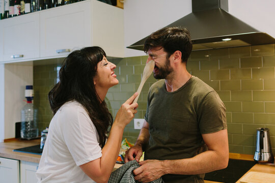 Woman making fun of her husband in the kitchen