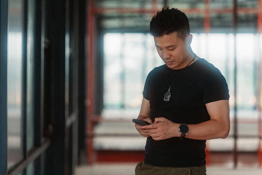 Portrait of Asian man holding mobile phone in hand