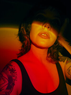 Portrait of a tattooed woman with red and black lighting