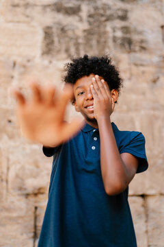 Young Man Covering Eye And Reaching Out To Camera