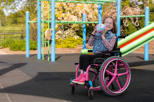 Girl in wheelchair playing on playground