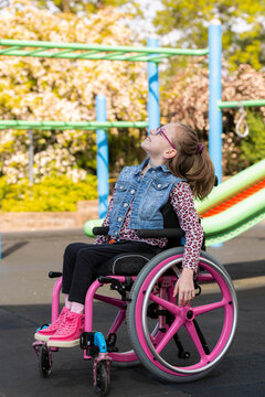 Girl in wheelchair playing on playground