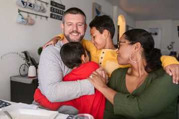 Diverse Family hugging together at home