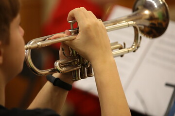 Hand with a trumpet close-up of a young man playing a musical instrument