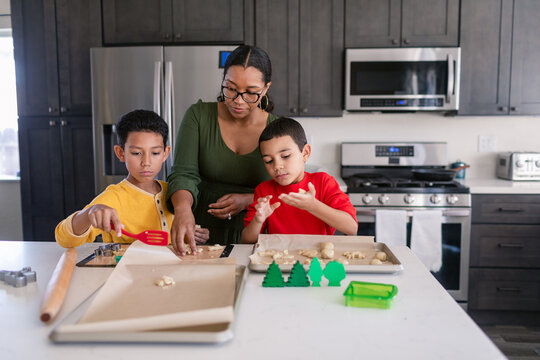 Mother and sons making christmas cookies at home