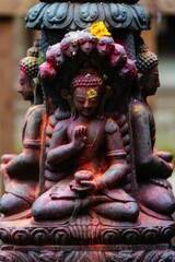 Black Buddha idol statue with red orange yellow colored powder in Durbar Square, Nepal