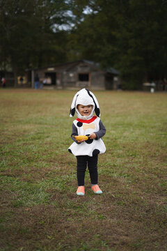 girl with a head of corn on the background of the house
