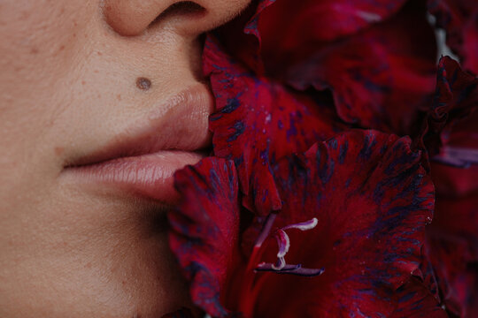Juicy lips and red flowers closeup shot
