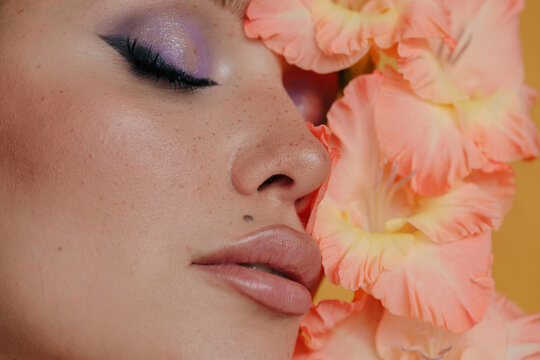 Closeup beauty portrait with closed eyes abd peachy flowers