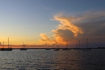 Sunset with anchored boats in the bay of La Paz in Mexico. Magnificent orange clouds.