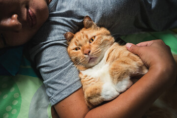 Asian woman hugging a cat.