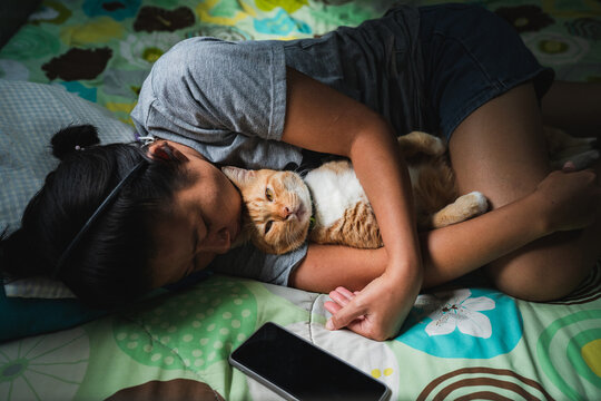 Asian woman hugging a cat.