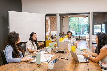 Diverse coworkers communicating at table in boardroom