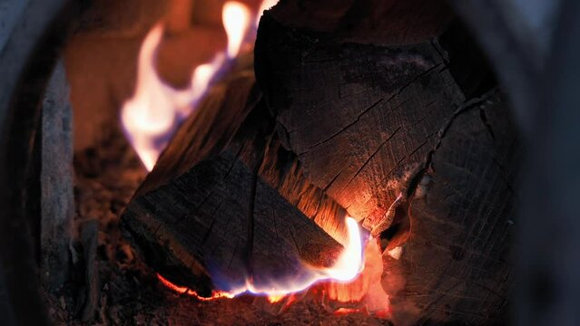 Burning fire in the furnace of a heating boiler. Burning firewood for space heating close-up