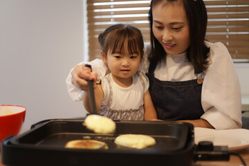 ホットケーキを焼く親子