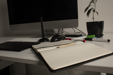 Comfortable place of work. Close-up top view of comfortable working place in office with and laptop. Workplace of designer. Notebook on the table. Business diary. Work at home. Place for making art.

