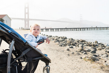 Little baby looking over side of the stroller on his travels