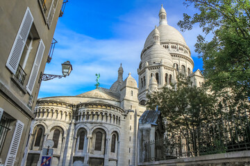 Fototapeta na wymiar Basilica of Sacre-Coeur in Montmartre at sunny day with cloudscape, Paris