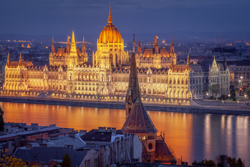 Fototapeta na wymiar Parliament illuminated and Danube River at dramatic evening, Budapest, Hungary