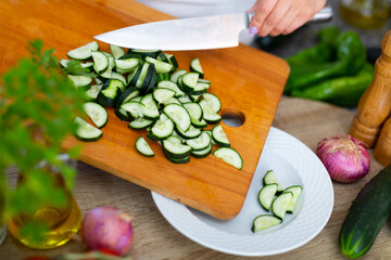 Closeup of slicing fresh cucumber on cutting board