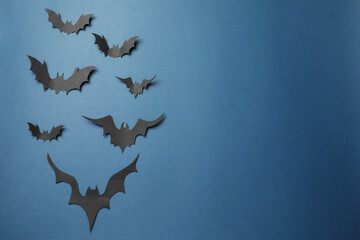 Many paper bats on dark blue background, flat lay with space for text. Halloween celebration