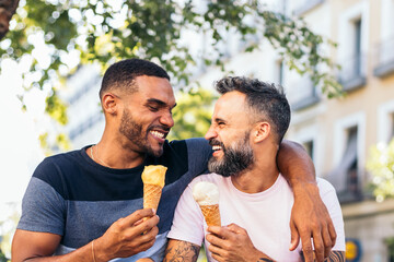 Gay couple eating ice cream and having fun outdoors