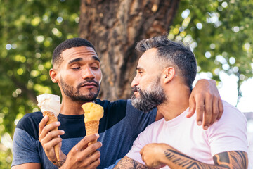 Gay couple eating ice cream and having fun outdoors