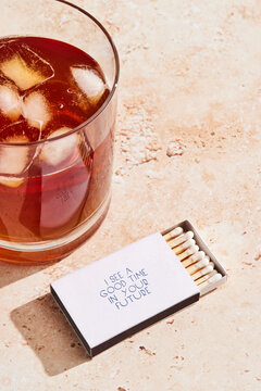 Iced whiskey drink and a box of matches