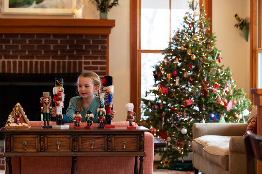 Girl Smiles With Nutcracker Toys In Home During Christmas 