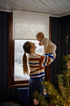 Woman With A Newborn Baby At The Window