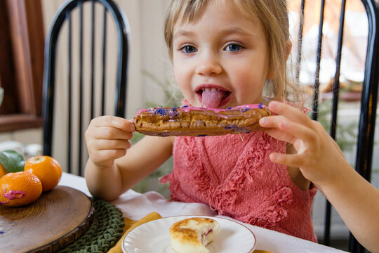 Cute girl eating eclair