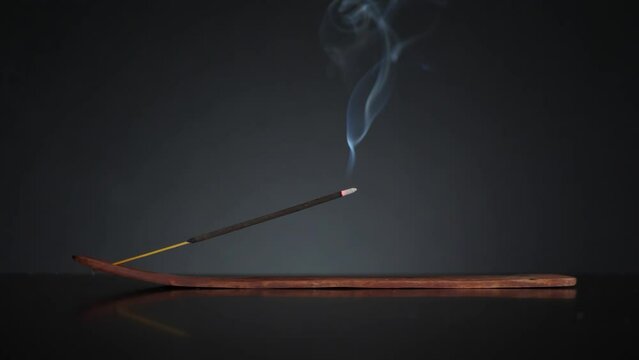 White smoke from meditative incense sticks on black background. Pure relaxation theme.