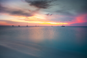 Aruba idyllic caribbean beach with boats at sunset, Dutch Antilles Sea