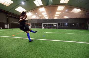 Teenagers practicing to on football pitch with friends