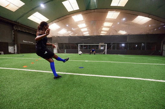 Teenagers practicing to on football pitch with friends
