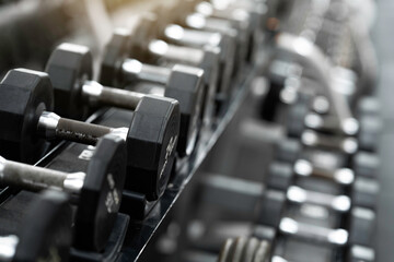 Fototapeta na wymiar Rows of dumbbells in the gym, Close up many metal dumbbells on rack in the sports fitness center, Weight Training Equipment concept.