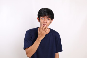 Dumbfounded asian young man standing over white background