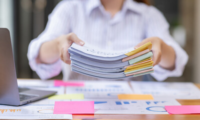 Close up of Business hands working in Stacks of paper files for searching information on work desk...