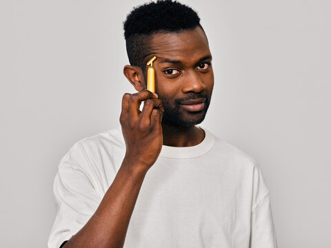 Man using electric facial roller