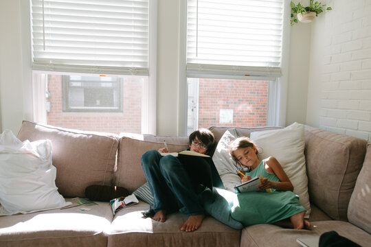 Kids Do Homework On Couch