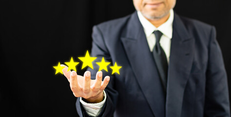 hand of businessman or customer holding stars to complete five stars for satisfaction service mind. he smiles and is happy before giving five star rating. Service rating, satisfaction concept.