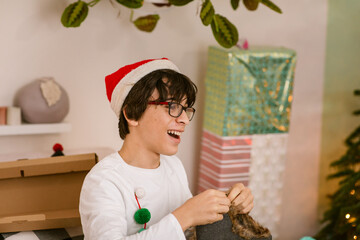 Happy teen opening gifts on Christmas Day at home