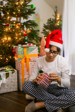Teen boy unwrapping gift at Christmas