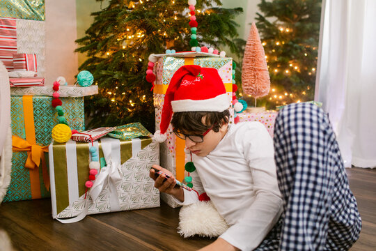 Teen boy checking phone at Christmas morning