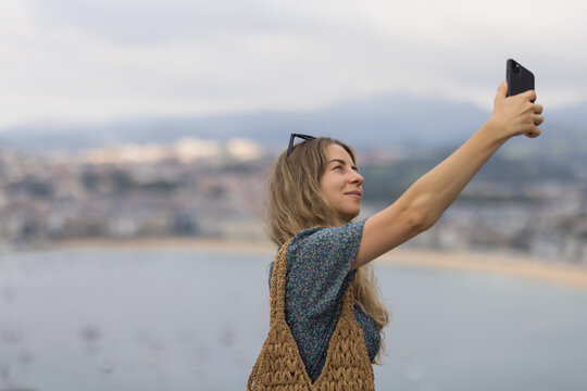 Young woman photographing city of San Sebastian, Spain.
