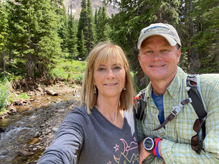 Selfie of active older couple hiking in the woods