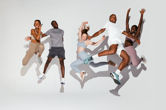 Happy diverse athletes jumping together