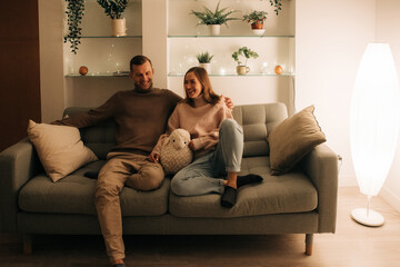 Couple relaxing on a couch at night